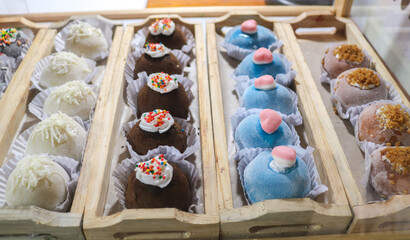 Various flavors of colorful fruit-shaped mochi in the display case
