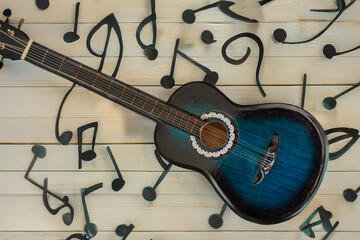 Fototapeta premium a blue classical guitar among the jumbled musical notes