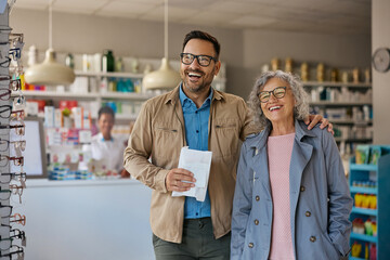 Fototapeta premium Satisfied man and his senior mother leaving pharmacy.