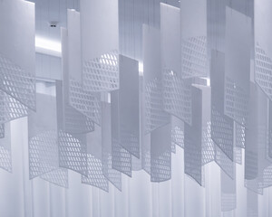 a series of geometric, lattice-patterned paper lanterns hanging from the ceiling. The lanterns are...