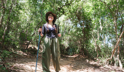 Happy woman hiking forest trail enjoying sunshine
