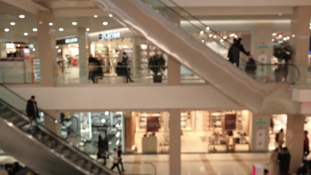 defocused background modern shopping center with many people walking and using escalators, representing consumerism, urban lifestyle, and vibrant atmosphere retail hub.