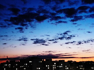 City skyline silhouette at twilight with colorful sky and dark clouds.