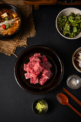 Premium Diced Beef with Korean Side Dishes on a Dark Table