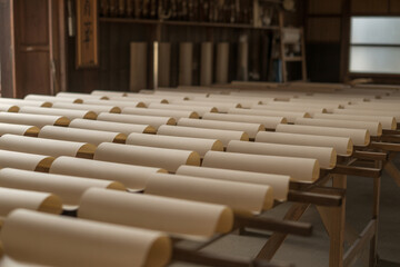 手漉き和紙の乾燥工程（紙が並ぶ工房）Rows of freshly made washi paper sheets drying on wooden racks inside traditional workshop