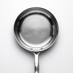Top view of a stainless steel skillet.  Features a smooth, round interior with a textured, patterned bottom.  Handle extends downward