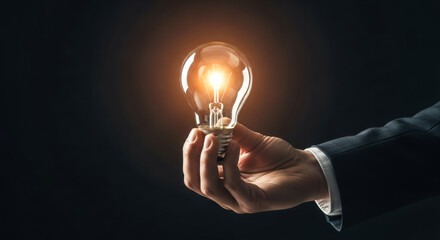 Businessman hand holding glowing lightbulb for concept of new idea, innovation, creative solution, inspiration and business strategy for success