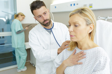 Obraz premium man doctor checking senior woman patient