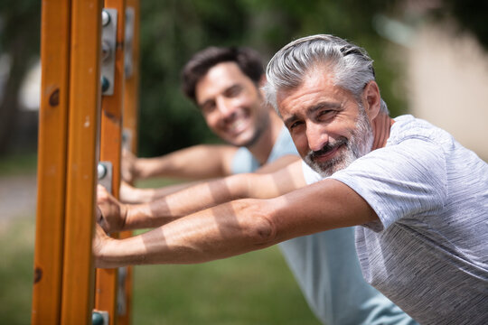 two men doing exercise in an outdoor fitness park