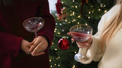 Festive gathering with cocktails near a decorated Christmas tree during holiday celebrations