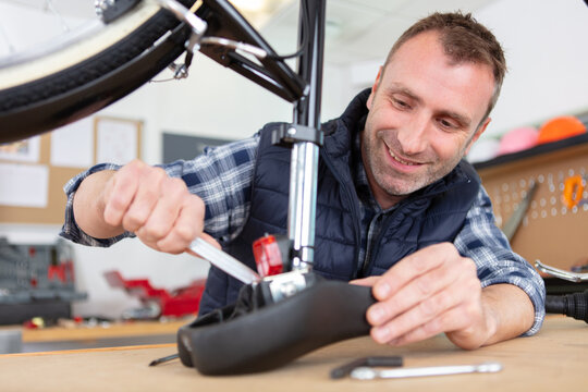 caucasian man repairing bicycle saddle - Powered by Adobe