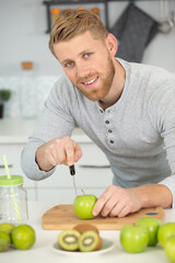 Fototapeta premium young man preparing fresh fruit juice