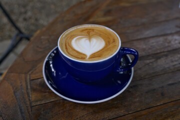 heart shaped latte art in blue coffee cup for cafe and beverage photography
