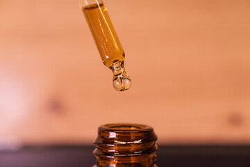 CBD oil drop macro close-up on pastel background, wellness skincare concept