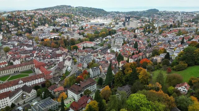 4k Drone Aerial Footage of saint gallen city in switzerland with autumn leaves and cloudy sky and the cathedral