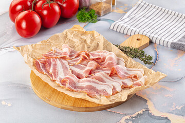 Sliced pork bacon over board