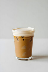 Refreshing iced coffee with creamy foam topping in a clear glass