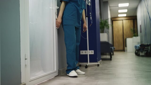 Overworked ICU nurse sitting on hallway floor after losing patient, burnout