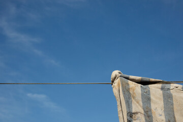 A string and a piece of dirty cloth. In the background, a blue sky and clouds.