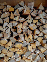 Close-up shot of a pile of birch firewood neatly stacked on top of each other