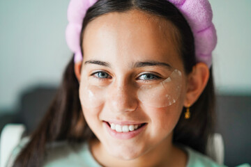 Female kid wearing skincare face mask - Cosmetic and children concept - Main focus on right eye