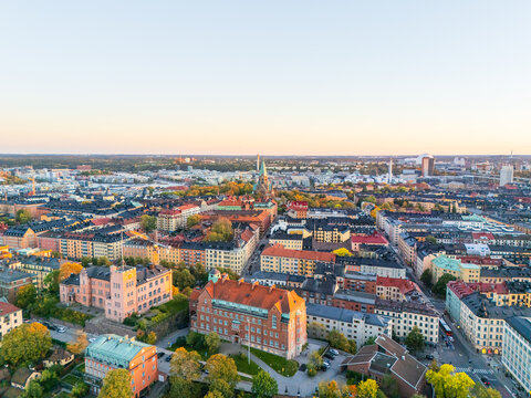 Aerial view of Stockholm's cityscape bathed in the soft glow of early morning light, with the iconic spire of Sofia church piercing the skyline, Stockholm, Stockholm County, Sweden.