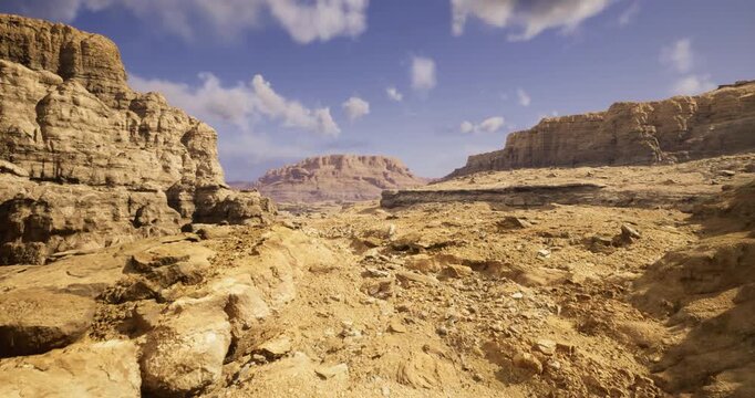 A vast desert stretches out with towering rock formations under a blue sky. The rugged terrain, dotted with stones and dust, creates an otherworldly atmosphere of tranquility.
