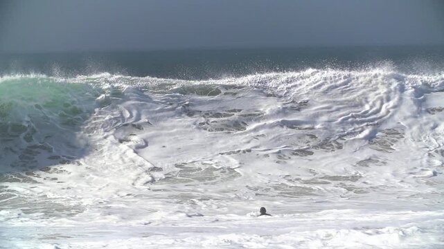 Bodyboarder escaping huge breaking waves
