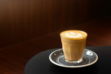 Delicious latte served in a clear glass with a beautiful leaf design on top, perfect for enjoying during a cozy coffee break