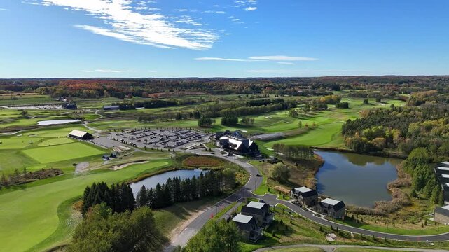 Sunny day aerial view of a golf resort surrounded by lush, mowed green lawns at TPC Toronto Osprey Valley Golf Course in Caledon, Ontario, Canada.