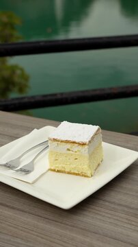 Vertical closeup Bled Cream Cake Krem&scaron;nita dessert at outdoor restaurant table in Slovenia