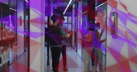 Naklejka premium Coworkers in sweaters discussing project in glass hallway, holding tablet, yellow folder, papers