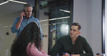 Professional taking notes and glancing across table in office meeting room, with mug, copy space