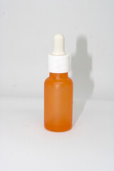 The orange minimalist skincare or essential oil container has a pipette for precise application.