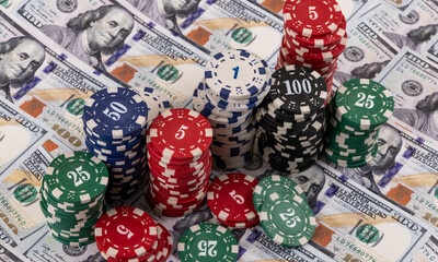 A conceptual story about ludomania (gambling addiction) with casino betting chips against a background of $100 bills.