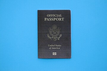 United States official passport book on light blue paper background close up. Travel document on blue surface