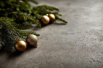 Softly lit close up of a christmas tree branch with golden baubles on a textured concrete surface