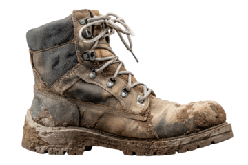 Dirty, used work boot with laces, covered in dried mud