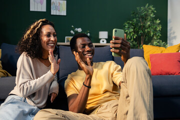 Diverse couple having video call on smartphone at home