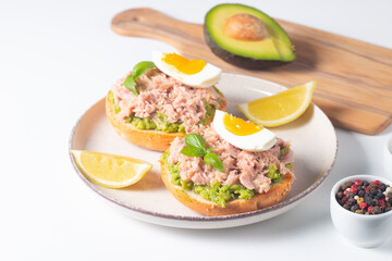 Two delicious tuna open sandwiches with avocado and boiled eggs. Tuna toast.