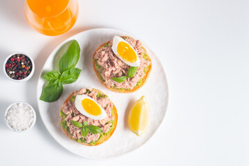 Two delicious tuna open sandwiches with avocado and boiled eggs. Tuna toast.
