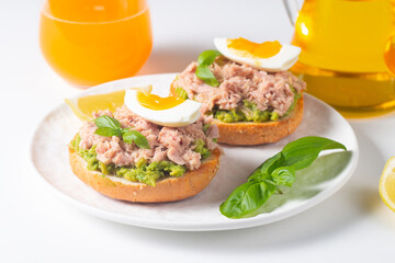 Two delicious tuna open sandwiches with avocado and boiled eggs. Tuna toast.