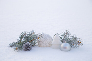 Christmas decorations and fir branches in fluffy snow. Copy space.