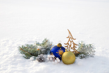 Christmas decorations and fir branches in fluffy snow. Copy space