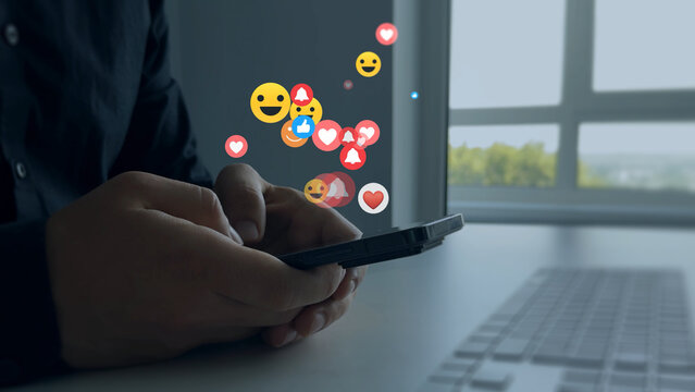 Interactive with friends on chat with emoticon feedback.Social media,marketing, like,social network,blog,live,chat reaction and livestream.Person using smart phone with emoticon icons of Social Media.
