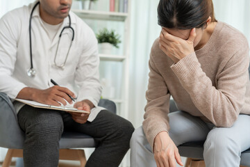 Female with mental health problems is consulting. psychiatrist is recording the patient condition...