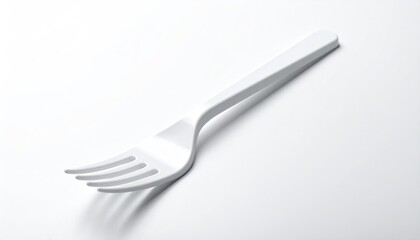 White plastic fork, four tines, on white surface, angled light