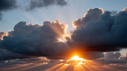 Dramatic sunset with sun rays shining through clouds.
