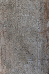 Weathered wood plank showing rough grain and traces of aged concrete, creating a distressed abstract surface perfect for rustic backgrounds, grunge overlays, or industrial design textures