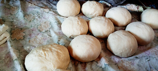 yeast dough for bread or pizza on a floured surface, with flour splash. Cooking bread. Kneading the...